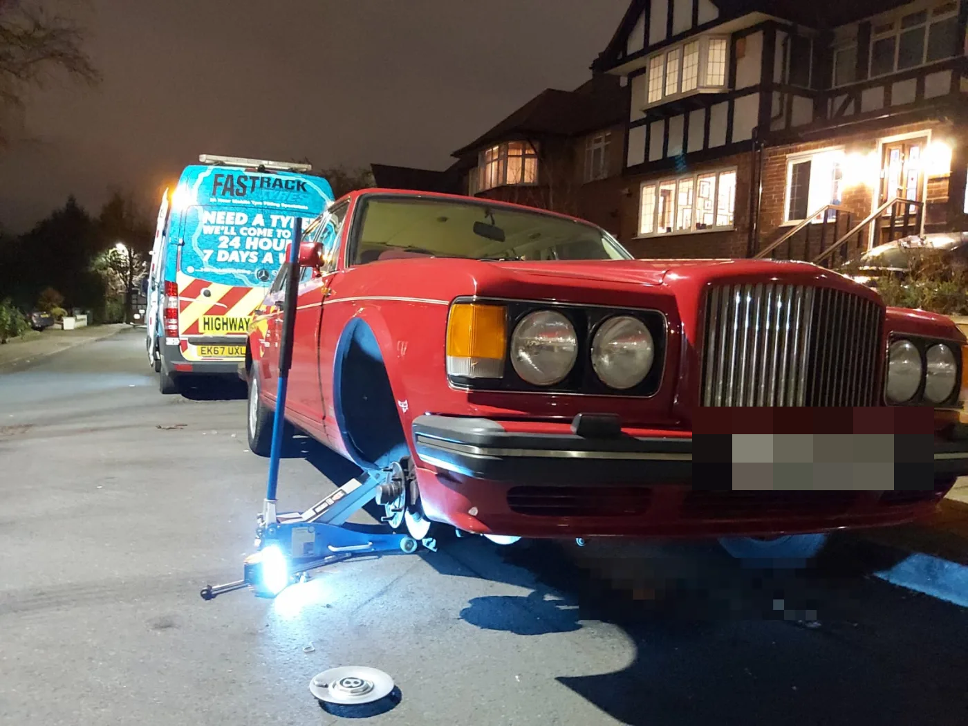 Classic red Bentley Turbo R on a night-time mobile tyre change outside a London home
