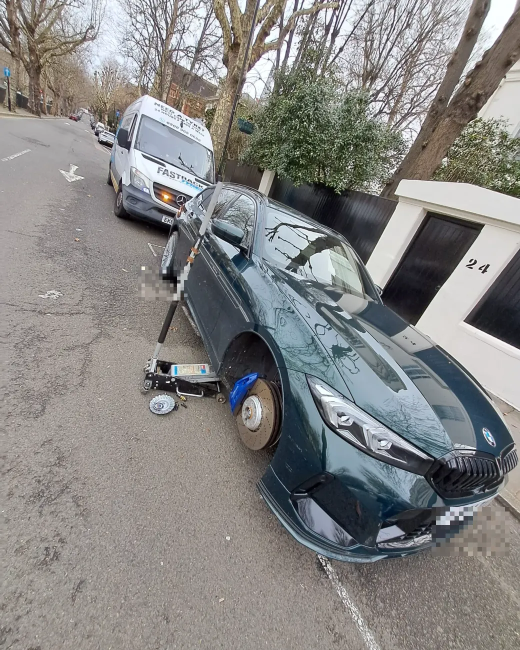 BMW Alpina with the front wheel off for a mobile tyre change on a London street
