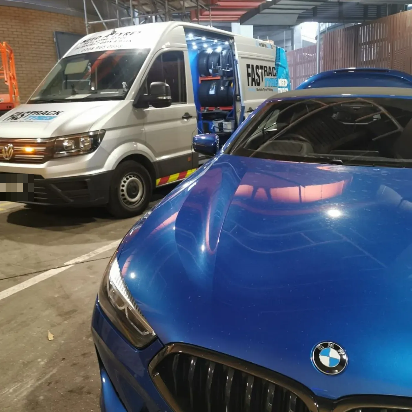 Blue BMW M8 beside the Fastrack vans on a daytime call-out