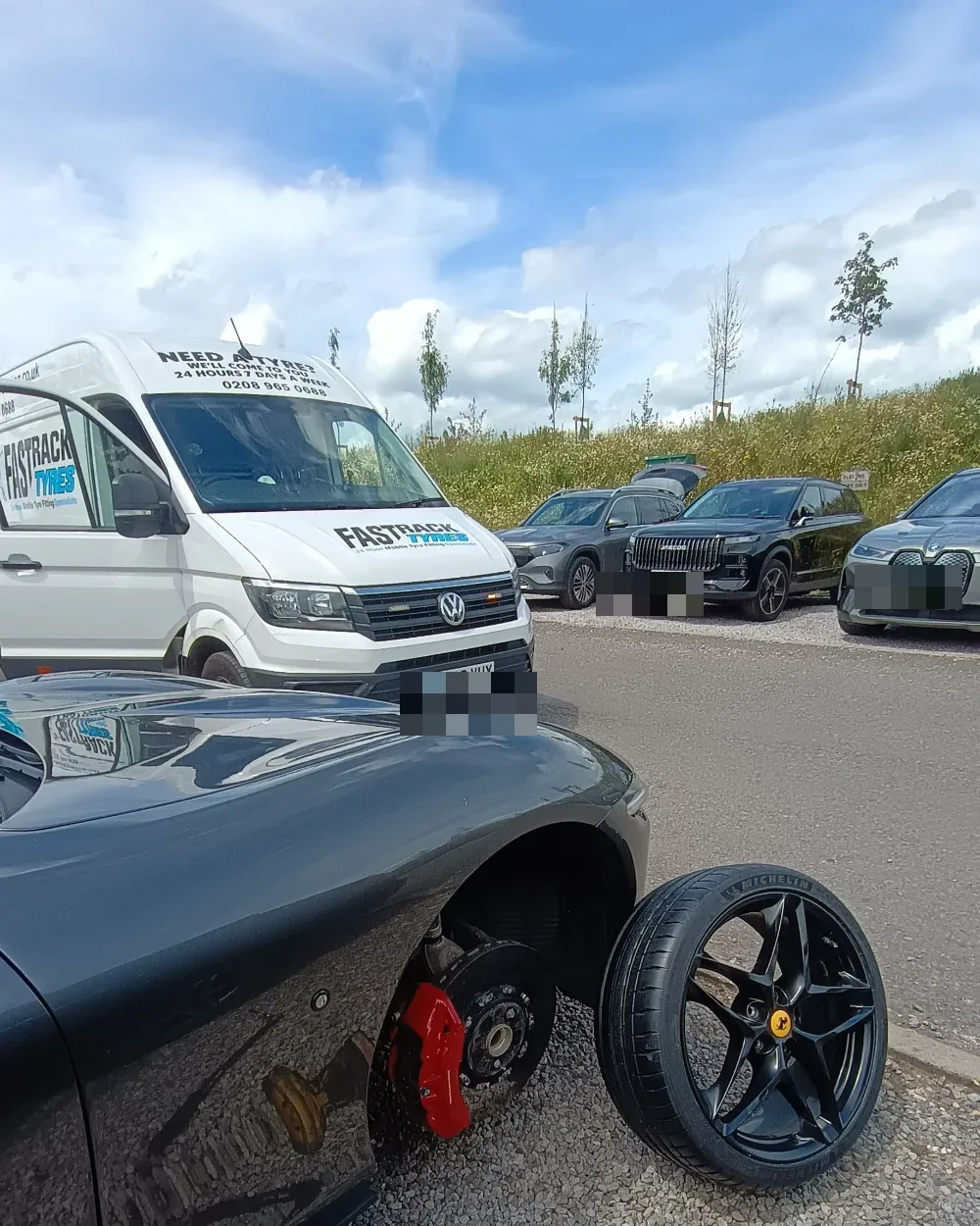 Ferrari Roma with the front wheel off and a new Michelin tyre during a mobile fitting