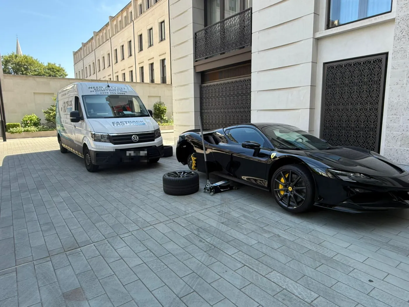 Ferrari SF90 with a wheel off for a mobile tyre fitting beside the Fastrack van