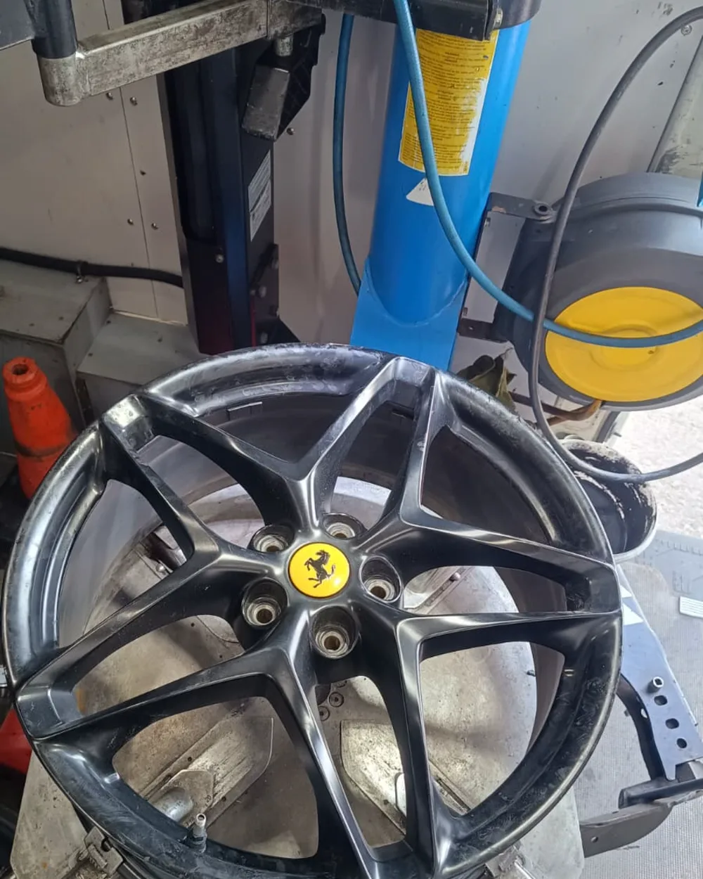Ferrari alloy wheel mounted on the tyre machine inside the Fastrack mobile workshop