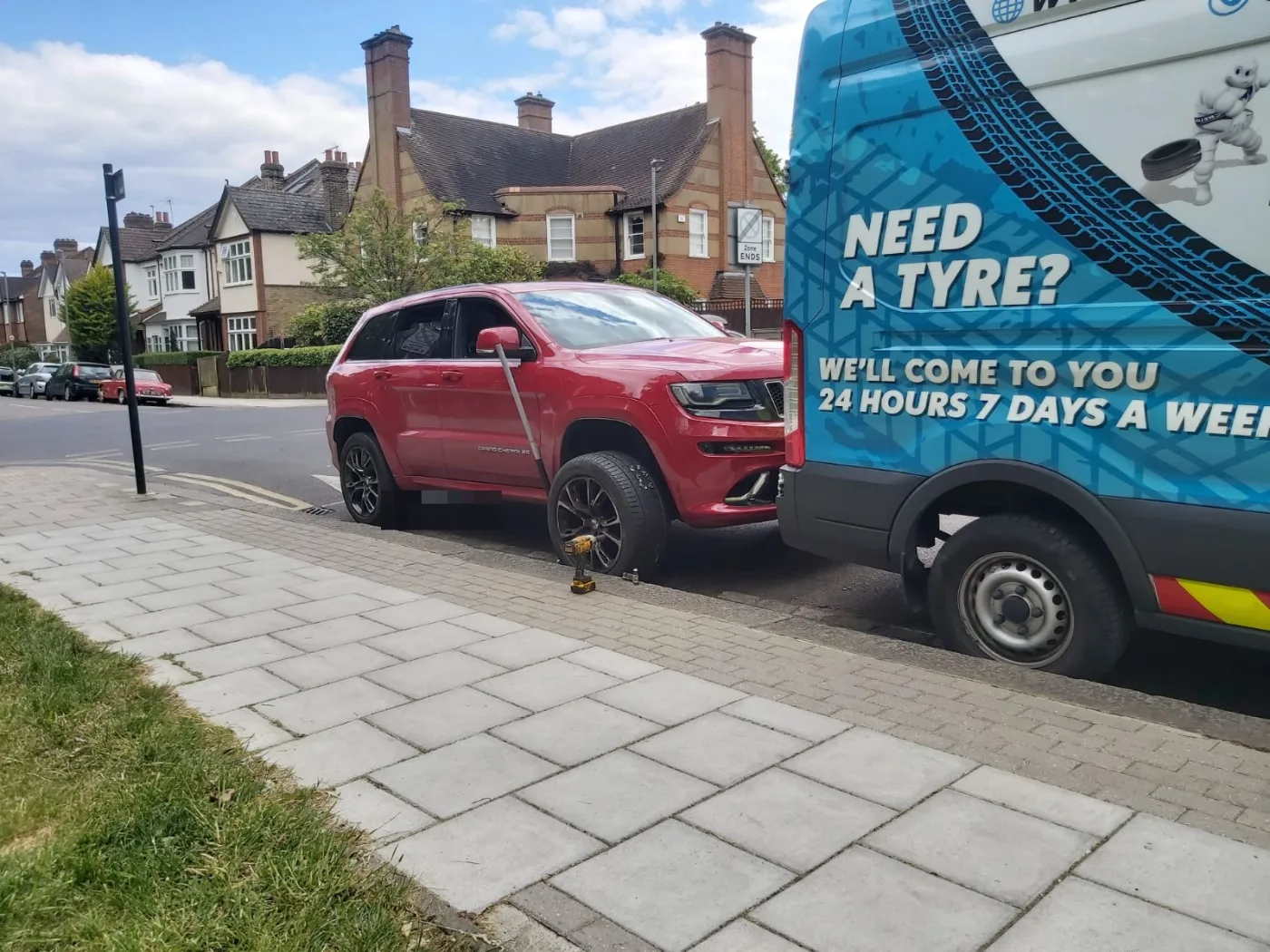 Red Jeep Grand Cherokee SRT having a tyre replaced at the roadside by Fastrack