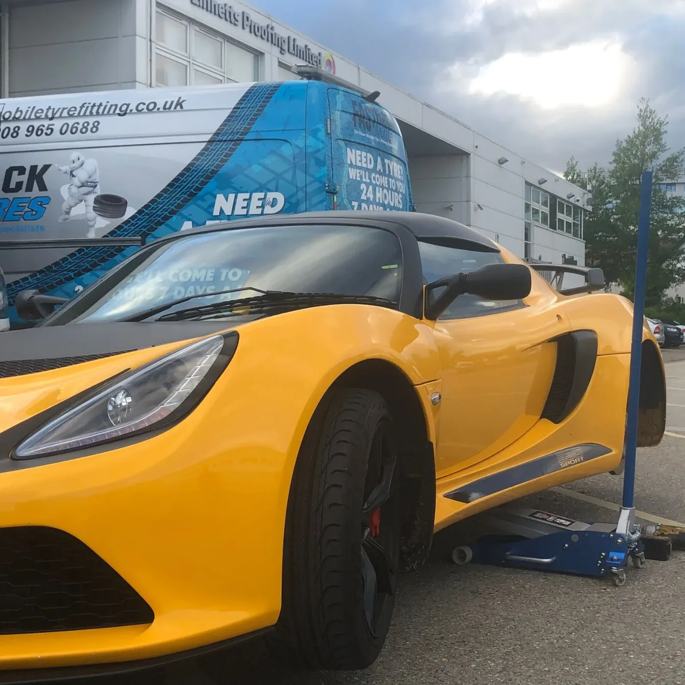 Yellow Lotus Exige Sport jacked up for a mobile tyre change