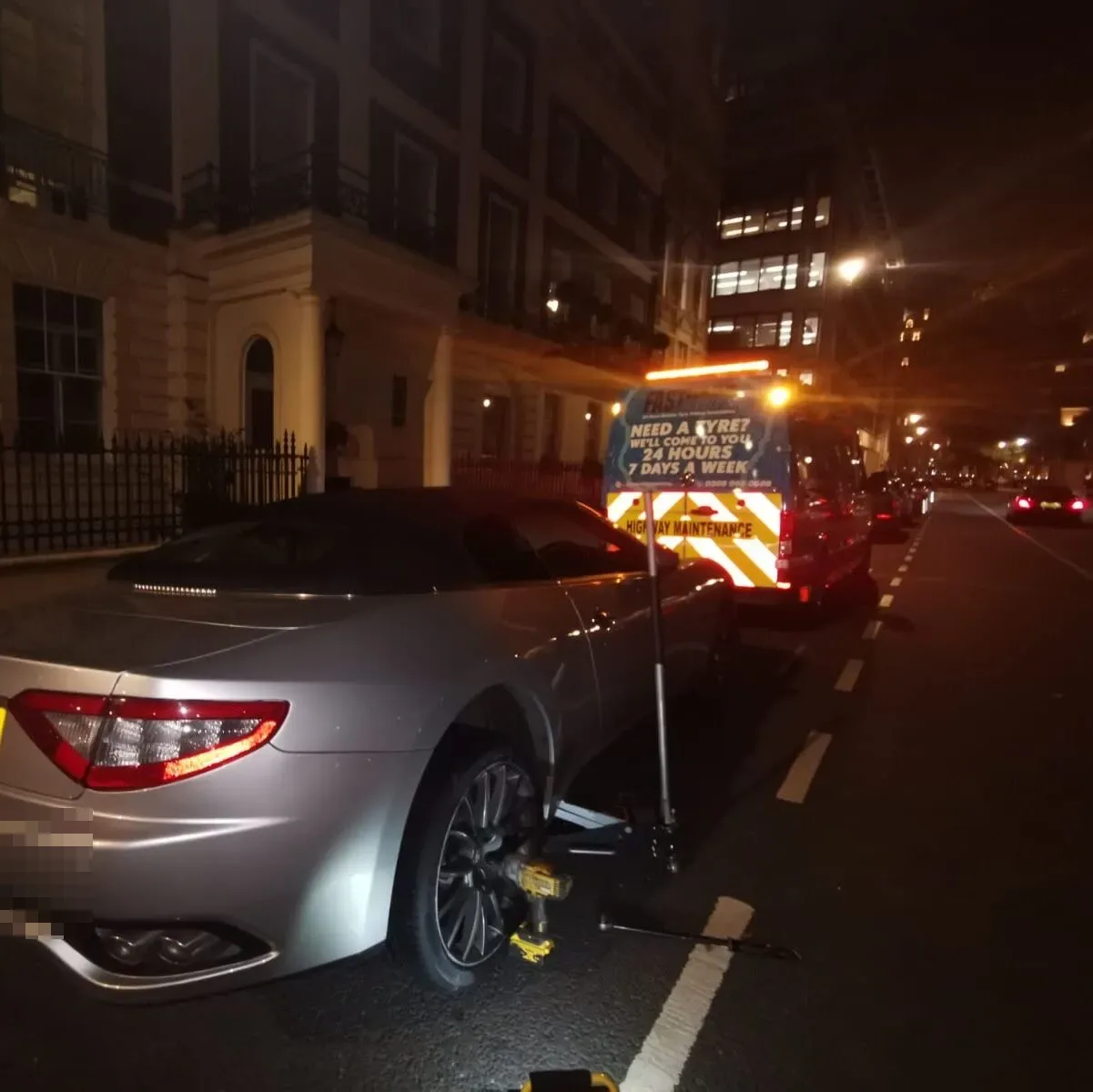 Silver Maserati GranCabrio on a Mayfair street at night during a mobile tyre change