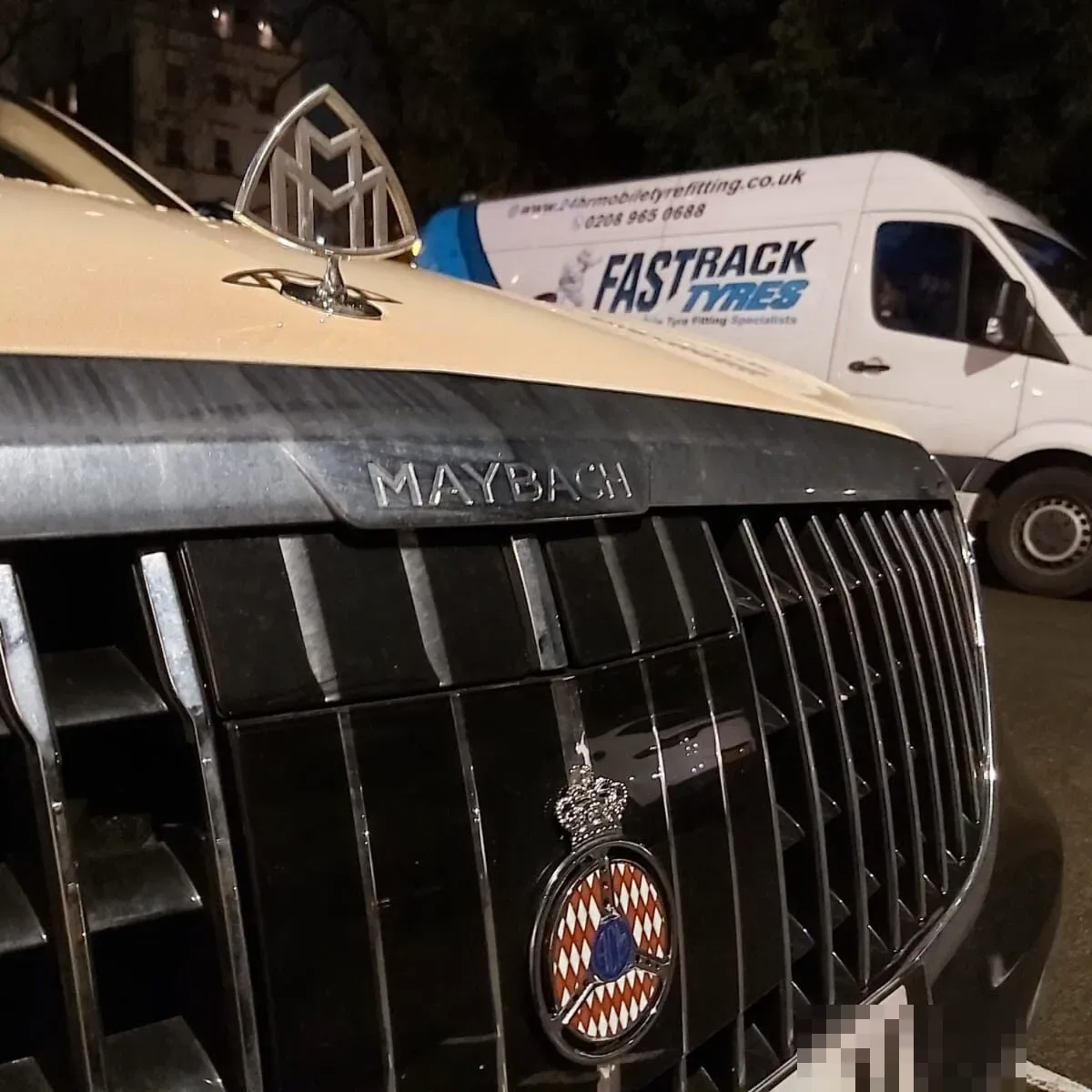 Close-up of a Mercedes-Maybach grille and crest during a night-time mobile tyre callout