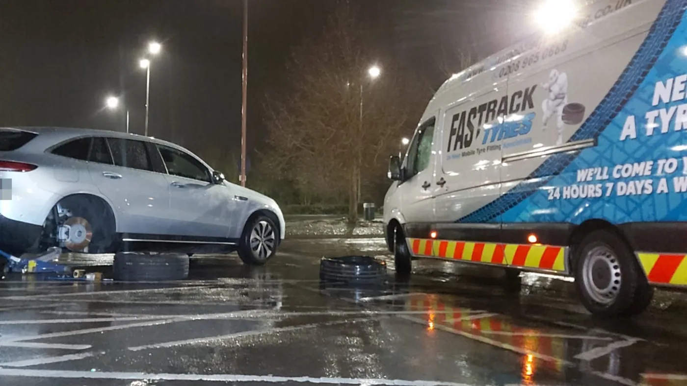 Mercedes EQC electric SUV on a wet night-time mobile tyre call-out, Fastrack van alongside
