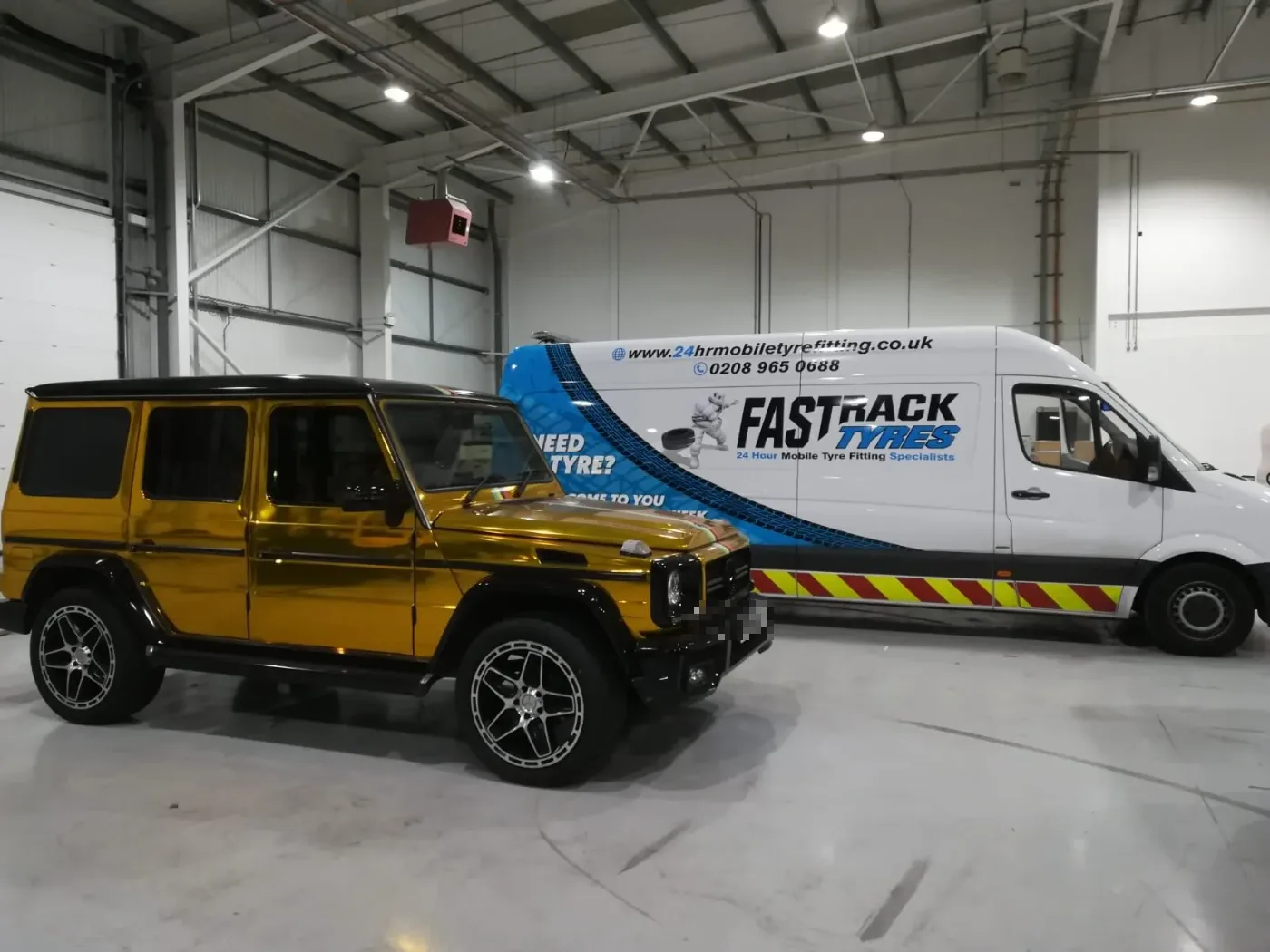 Gold chrome-wrapped Mercedes G-Class in a workshop with the Fastrack Tyres van alongside