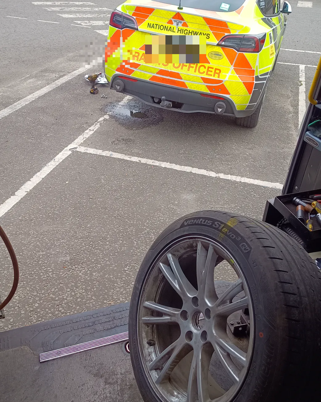National Highways Tesla traffic officer car having a tyre changed by Fastrack