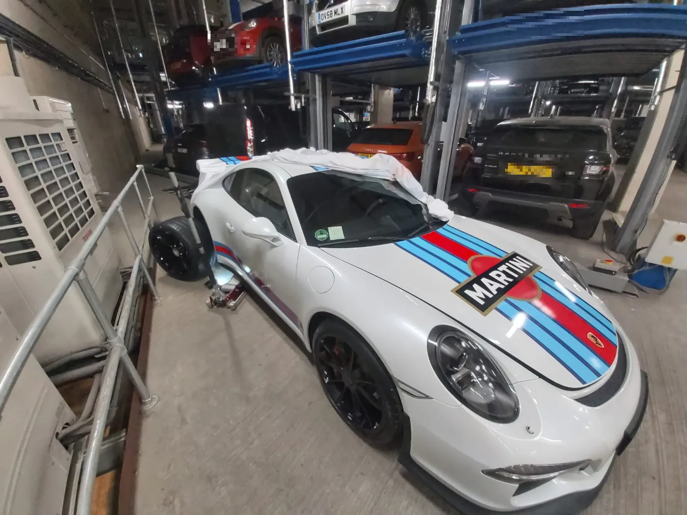 Porsche 911 in Martini Racing livery on a mobile tyre call-out in a car park