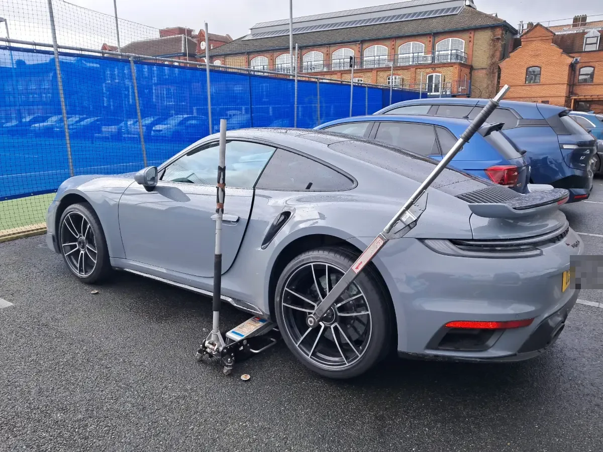 Grey Porsche 911 Turbo S on a trolley jack during a mobile tyre fitting