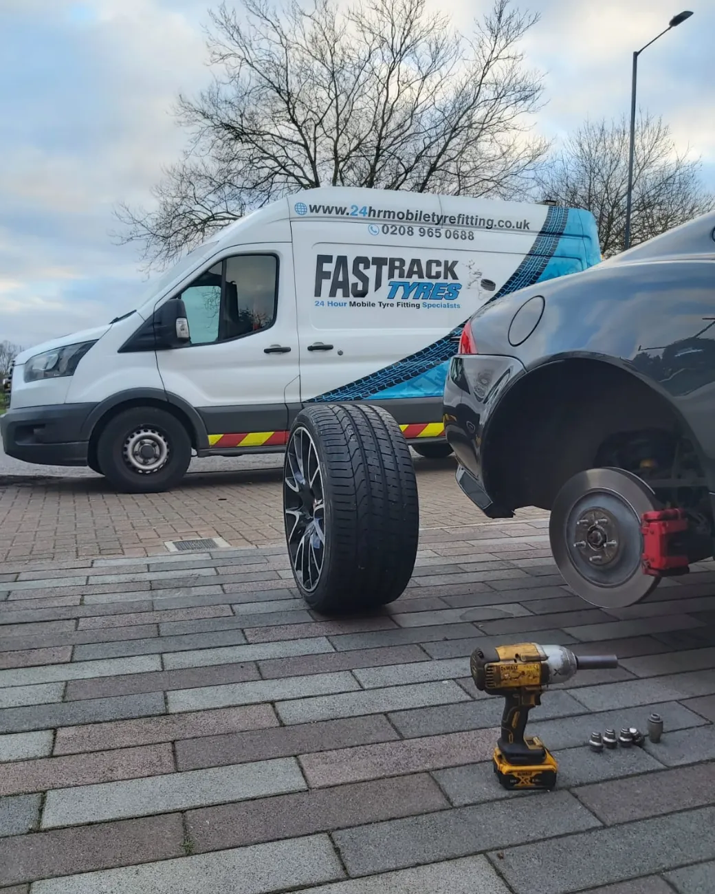 Roadside wheel-off tyre change beside the Fastrack Transit van