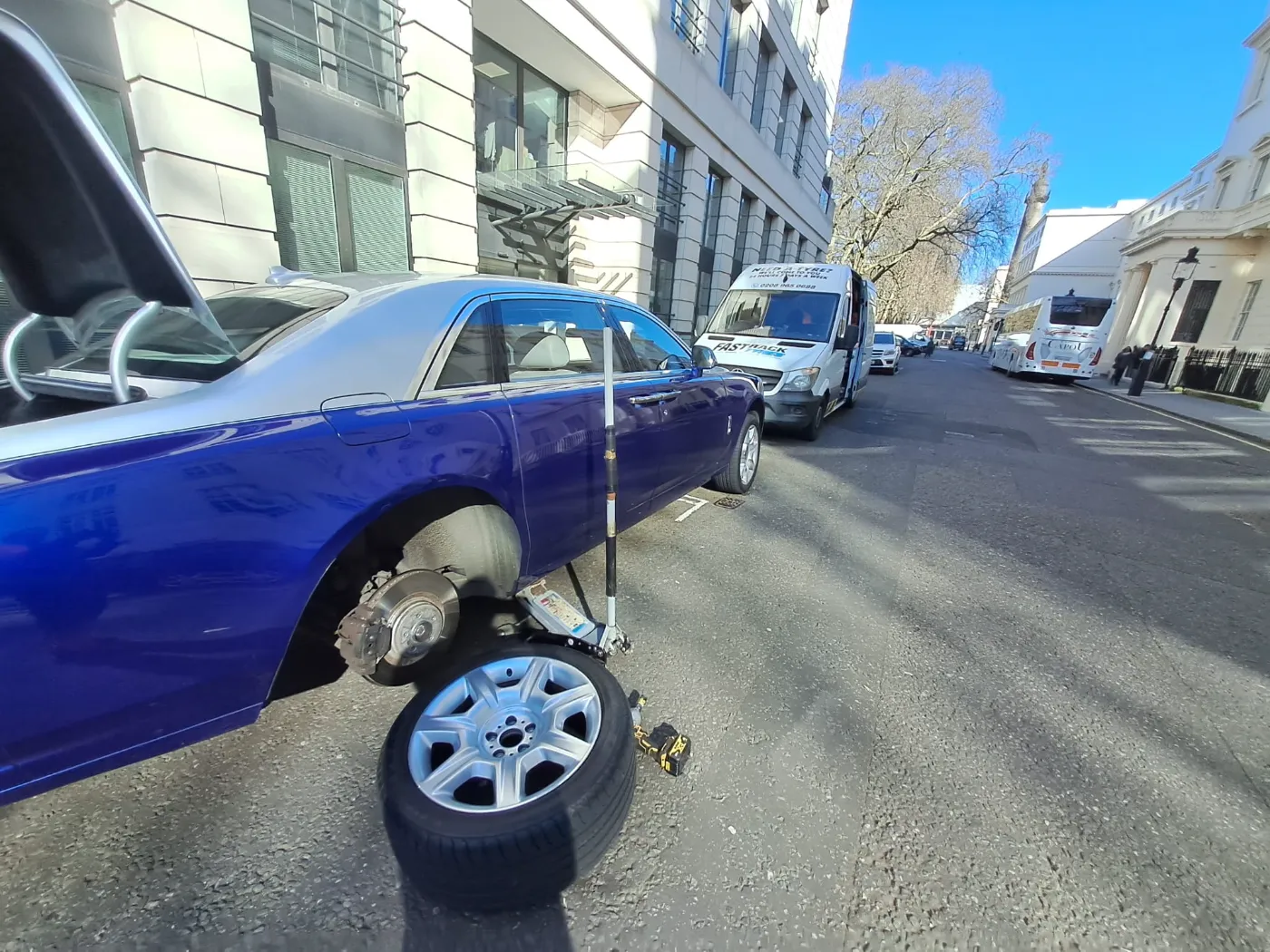 Two-tone blue Rolls-Royce Ghost with a wheel off for a mobile tyre change