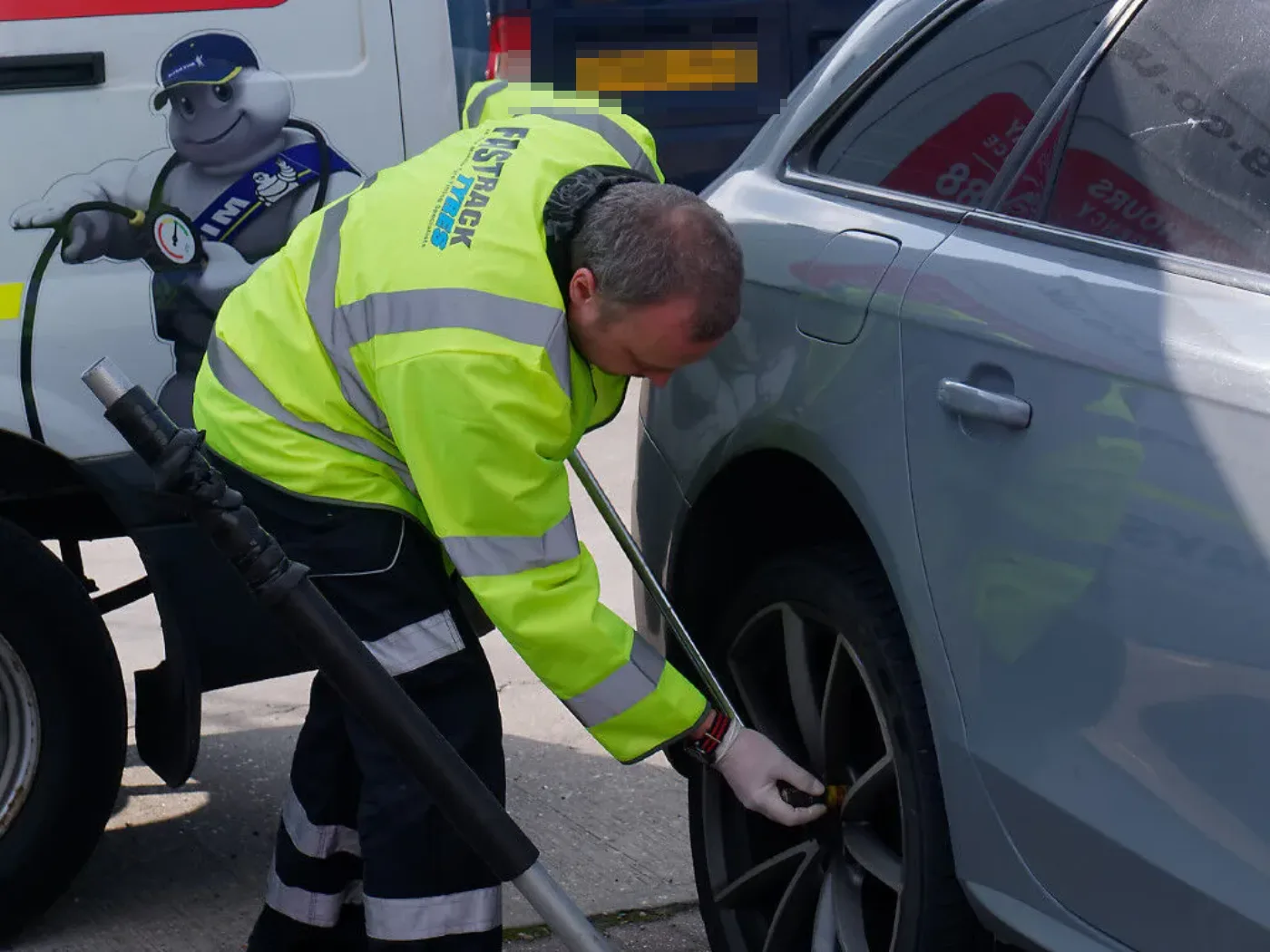 Fastrack technician torquing the wheel of a silver Audi on a daytime call-out