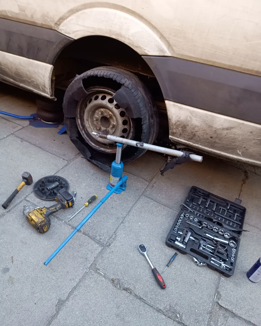 Flat van tyre with Fastrack tools laid out for a kerbside wheel change