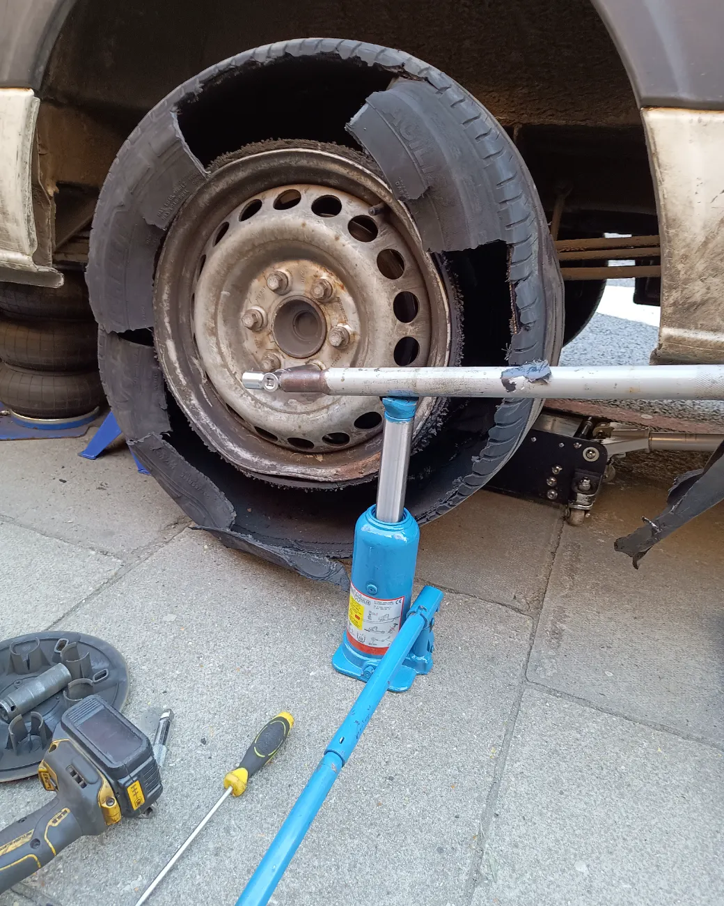 Damaged, deflated van tyre on a steel wheel during a roadside Fastrack replacement