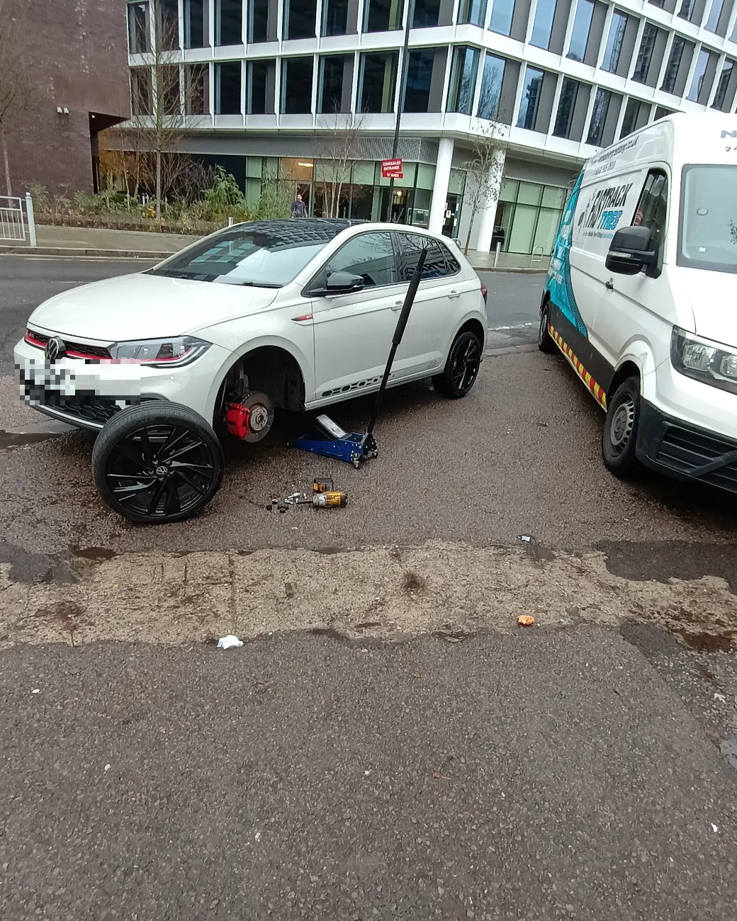 White VW Polo GTI having a wheel changed at the kerbside by Fastrack